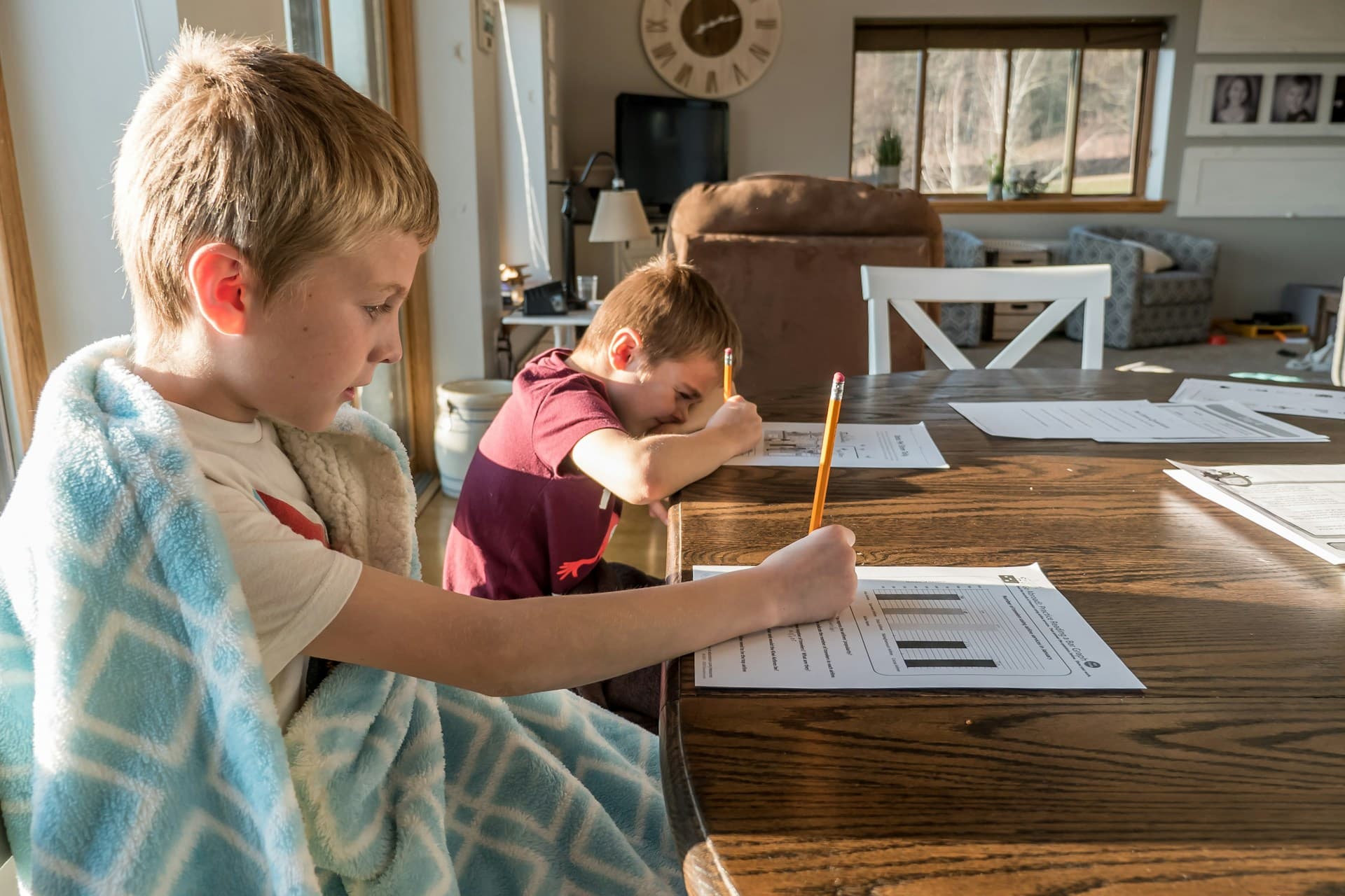 Child writing on board with teacher